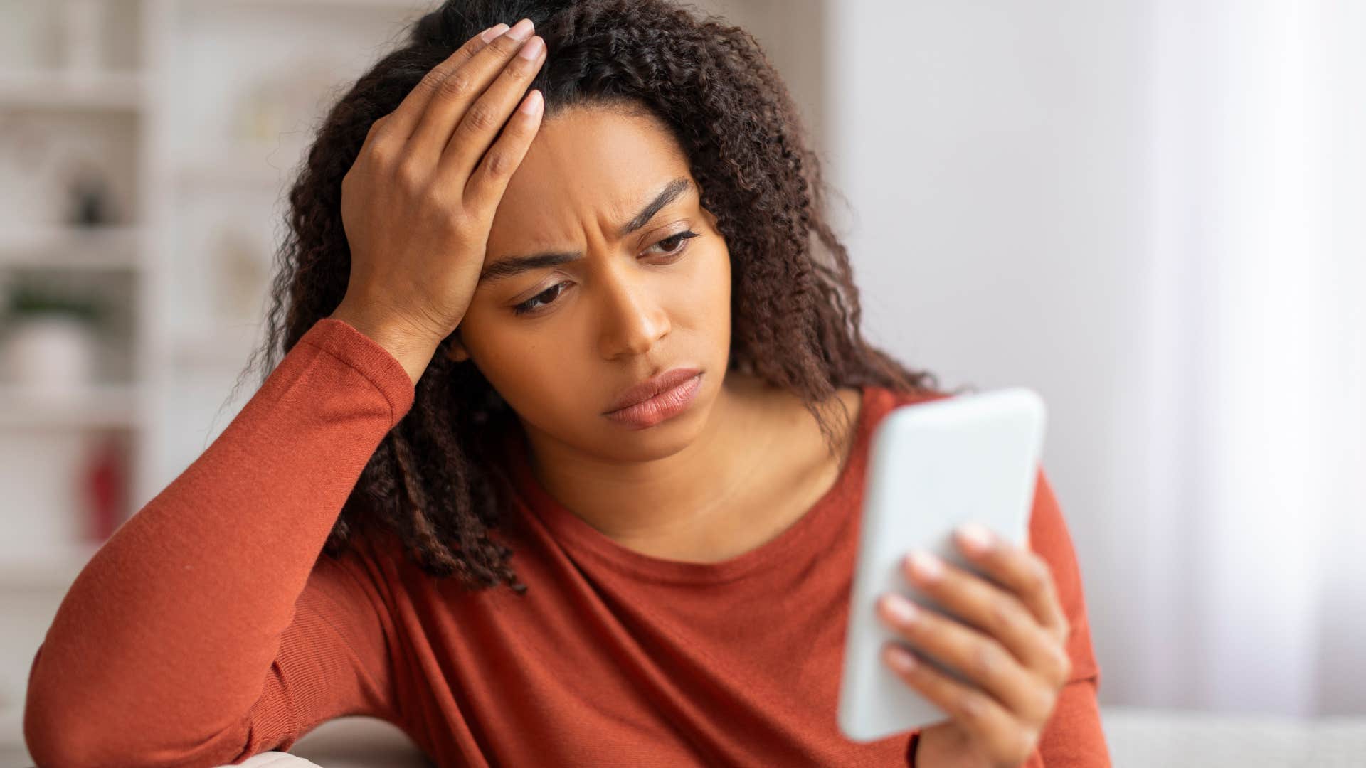 woman looking confused at her phone after being ghosted