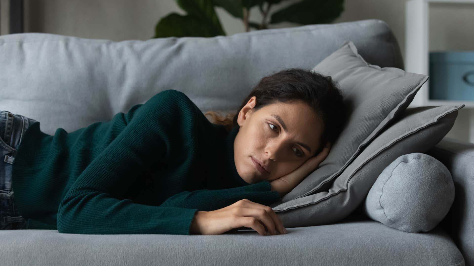 woman feeling guilty for resting on her couch