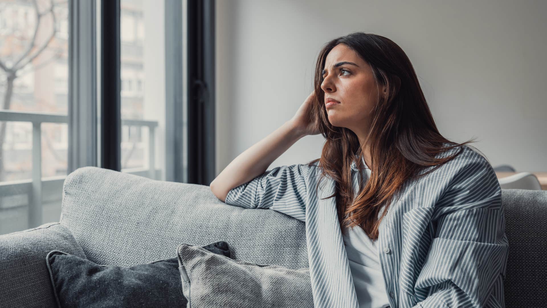 woman sitting on couch feeling overwhelmed