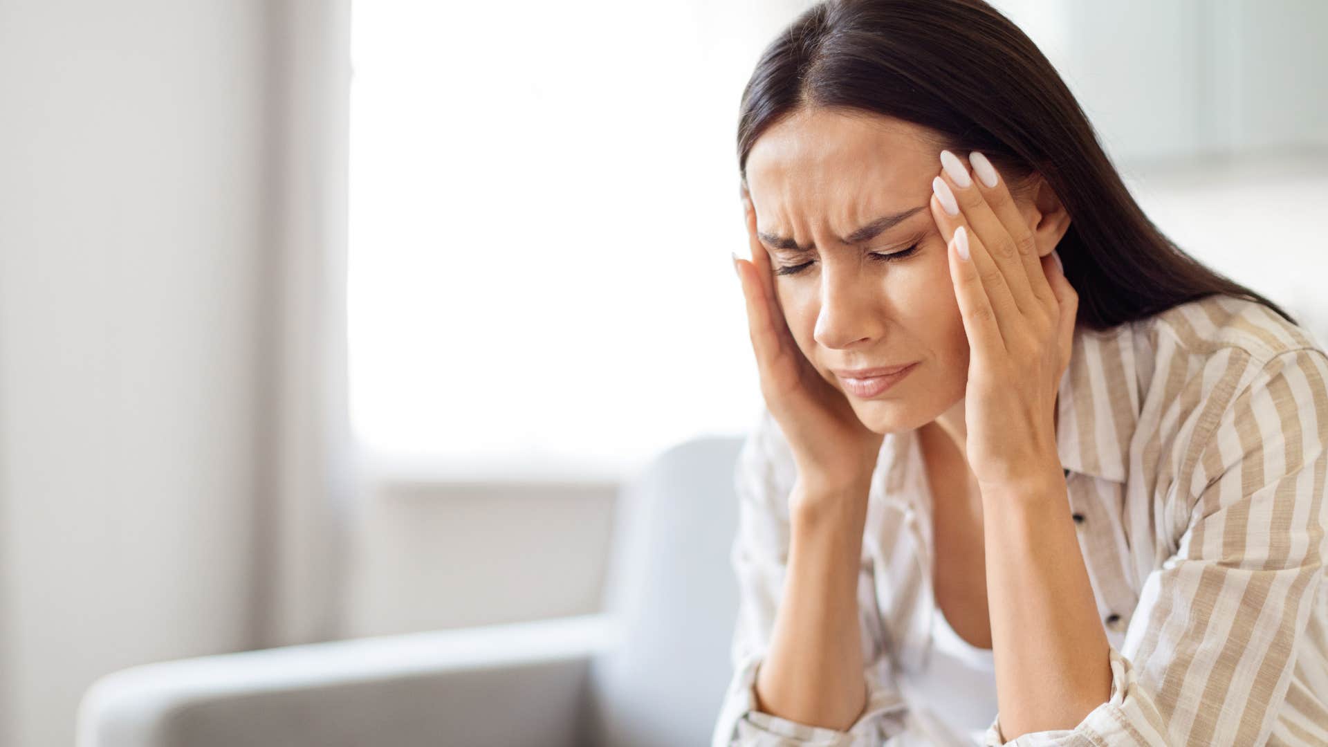 stressed woman rubbing the side of her head
