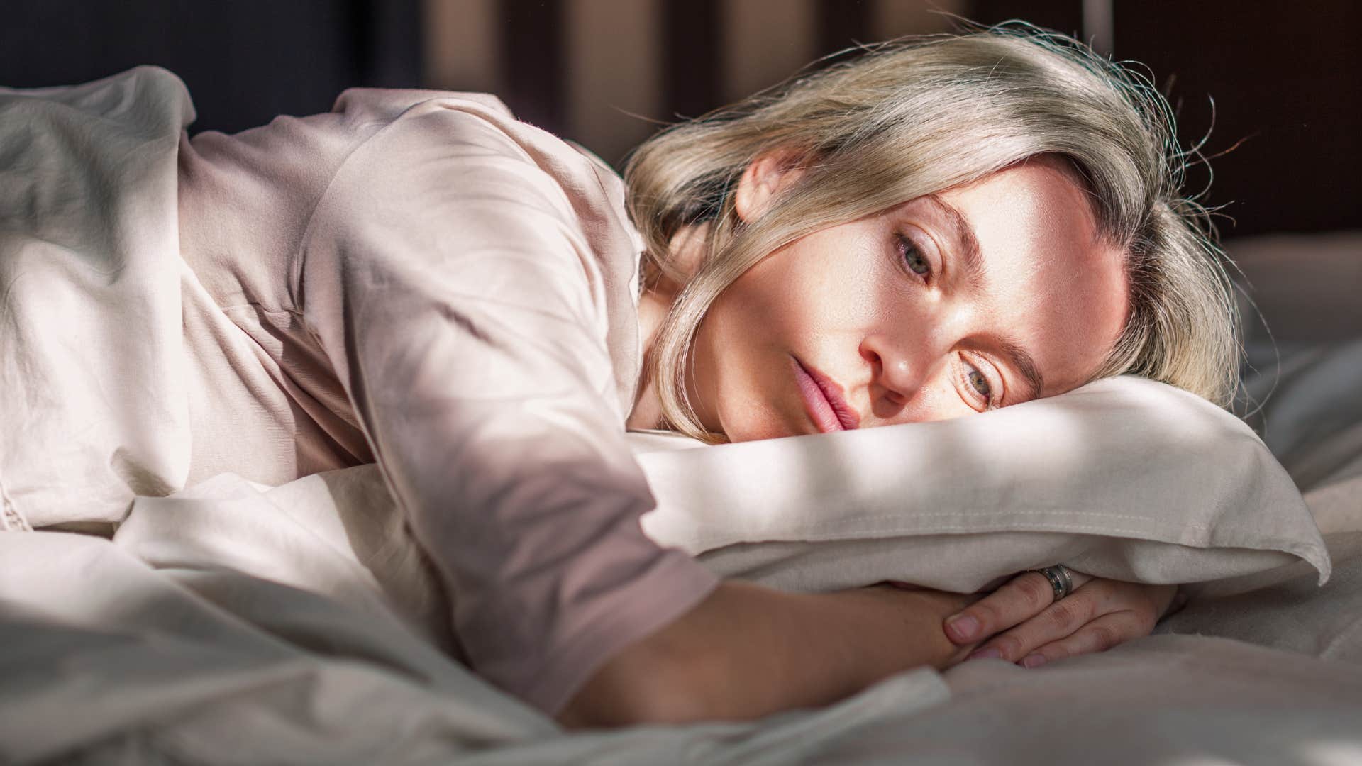 woman feeling overwhelmed laying in bed