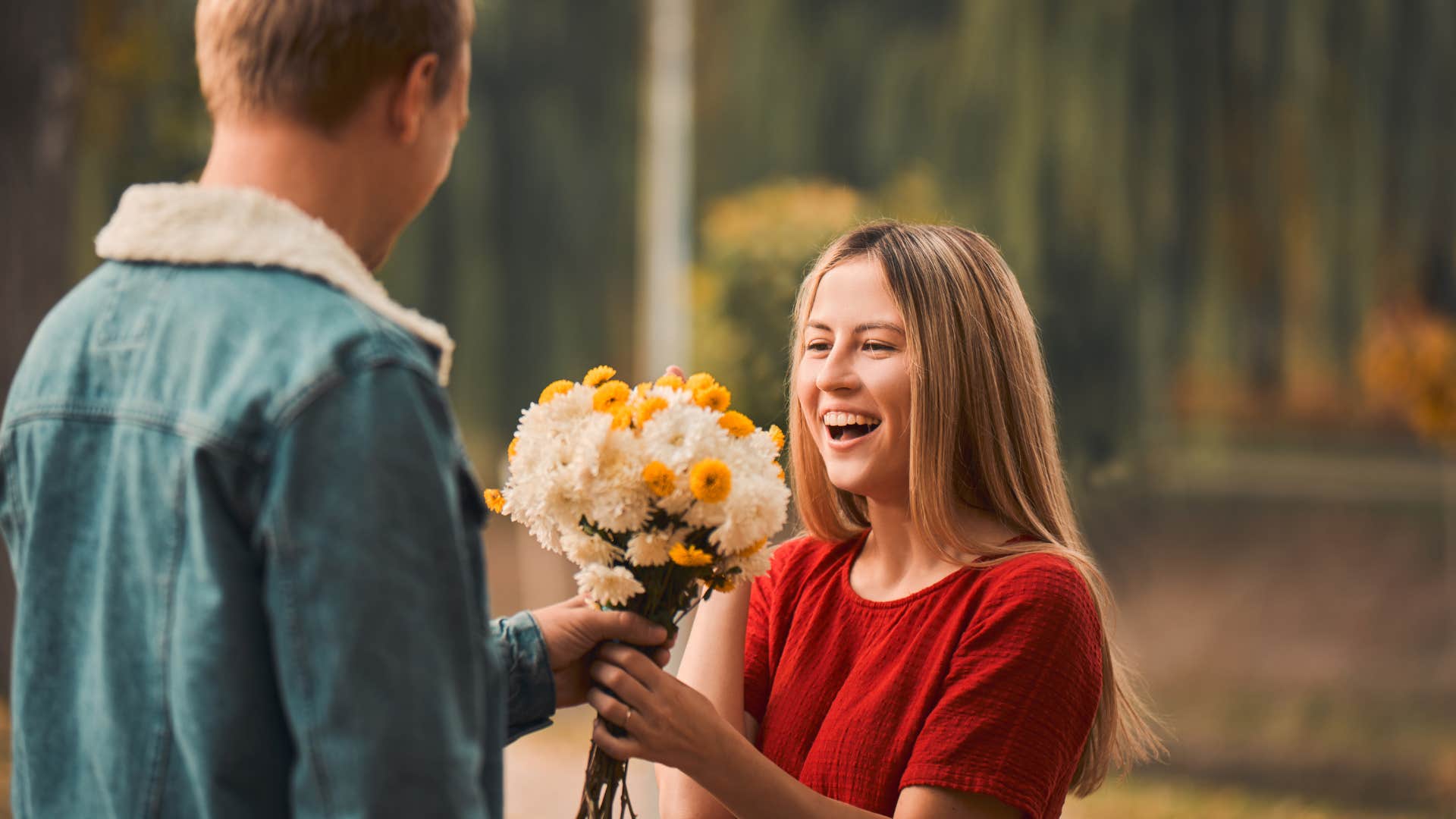 man giving woman flowers surprising her