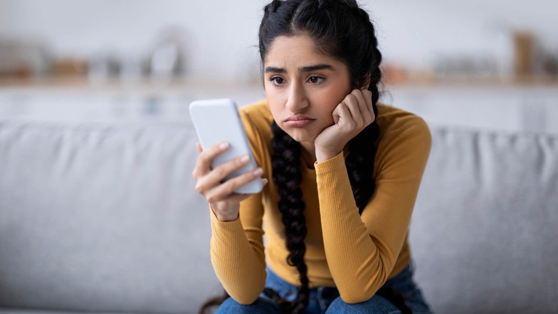 woman looking at her phone uninterested in it