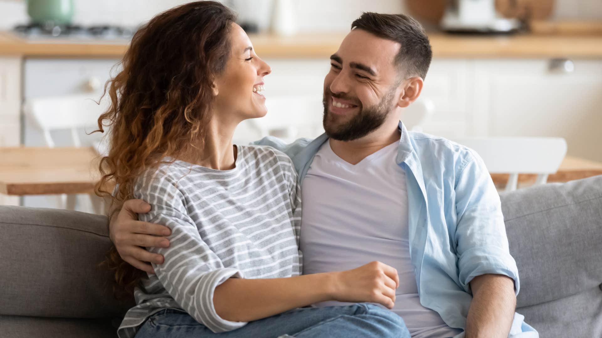 man being thoughtful with physical touch smiling at woman