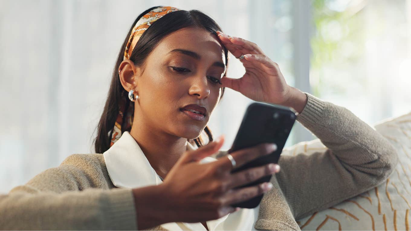stressed woman on her phone texting to cancel plans