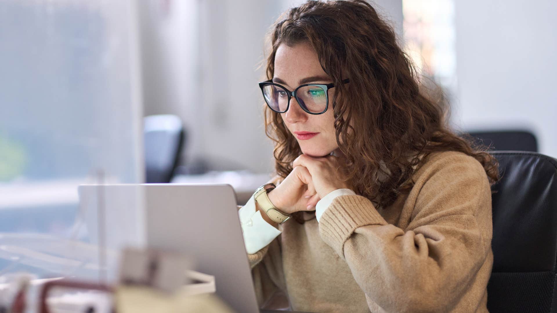 woman who takes credit for other people's work sitting at her desk