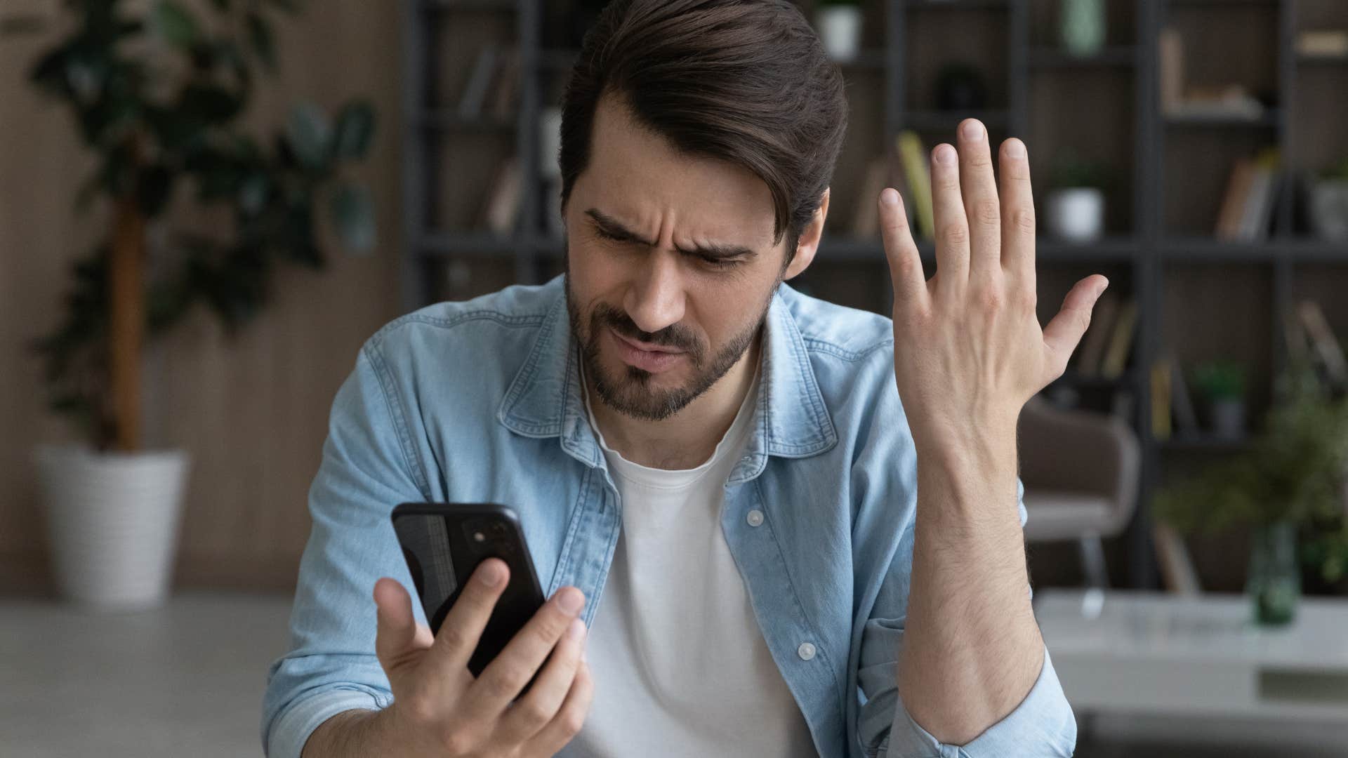unreliable man looking annoyed at his phone