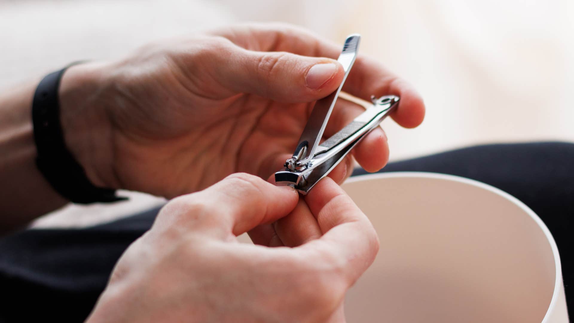 man clipping his nails in hotel room