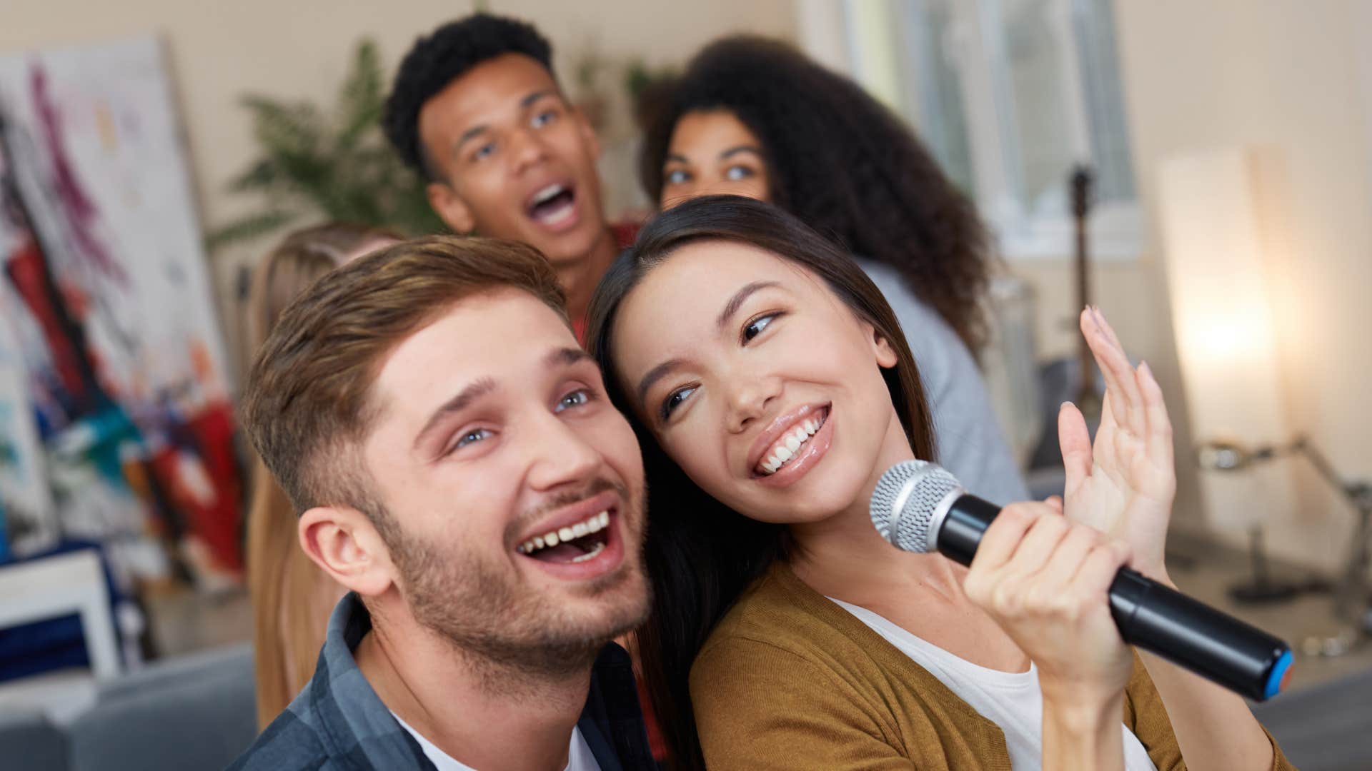 woman singing karaoke with partner and friends