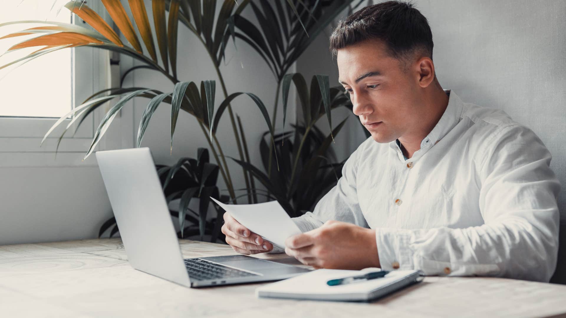 stressed man looking at bill and how much money he owes