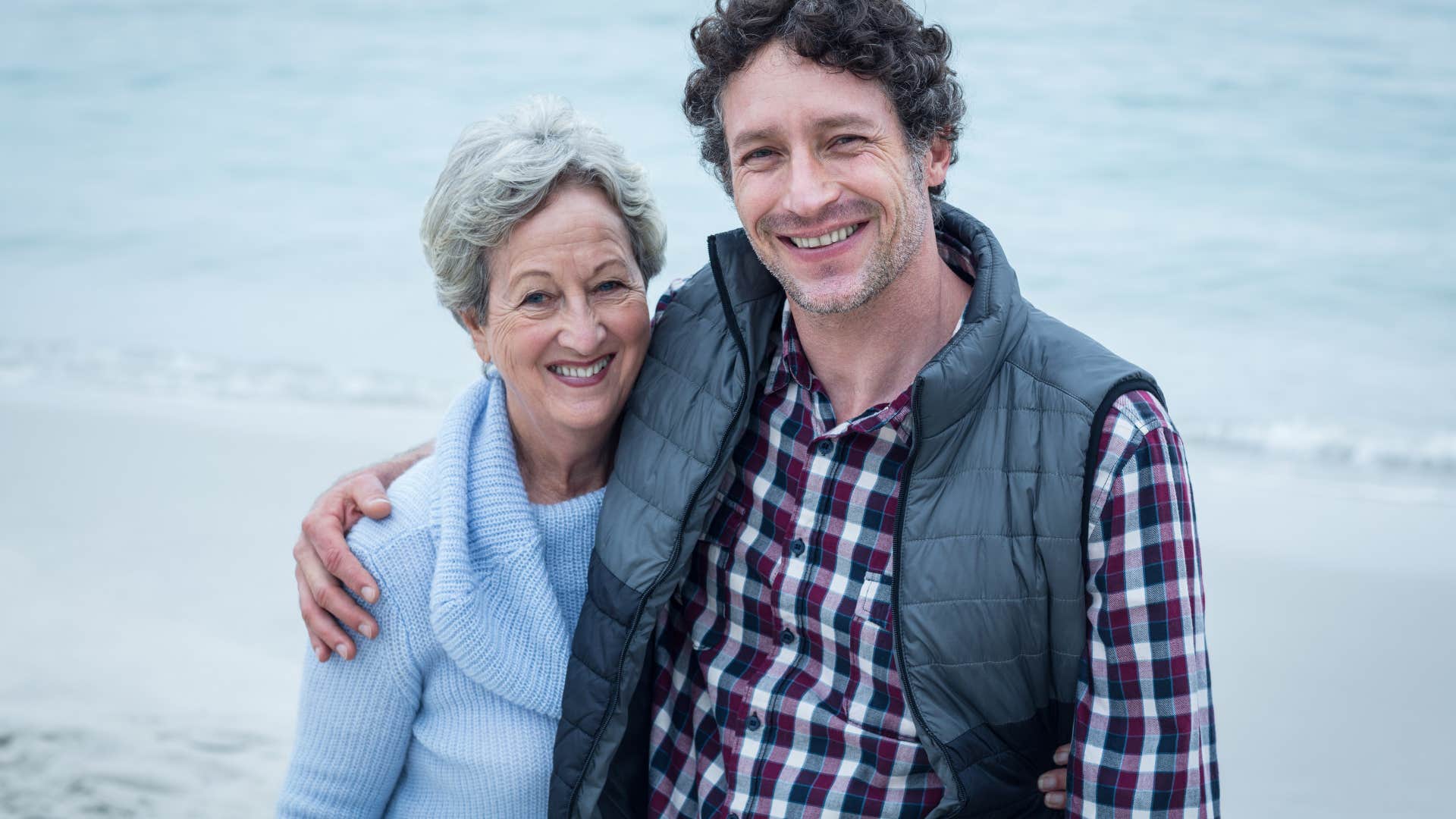 boomer mom and son in a side hug