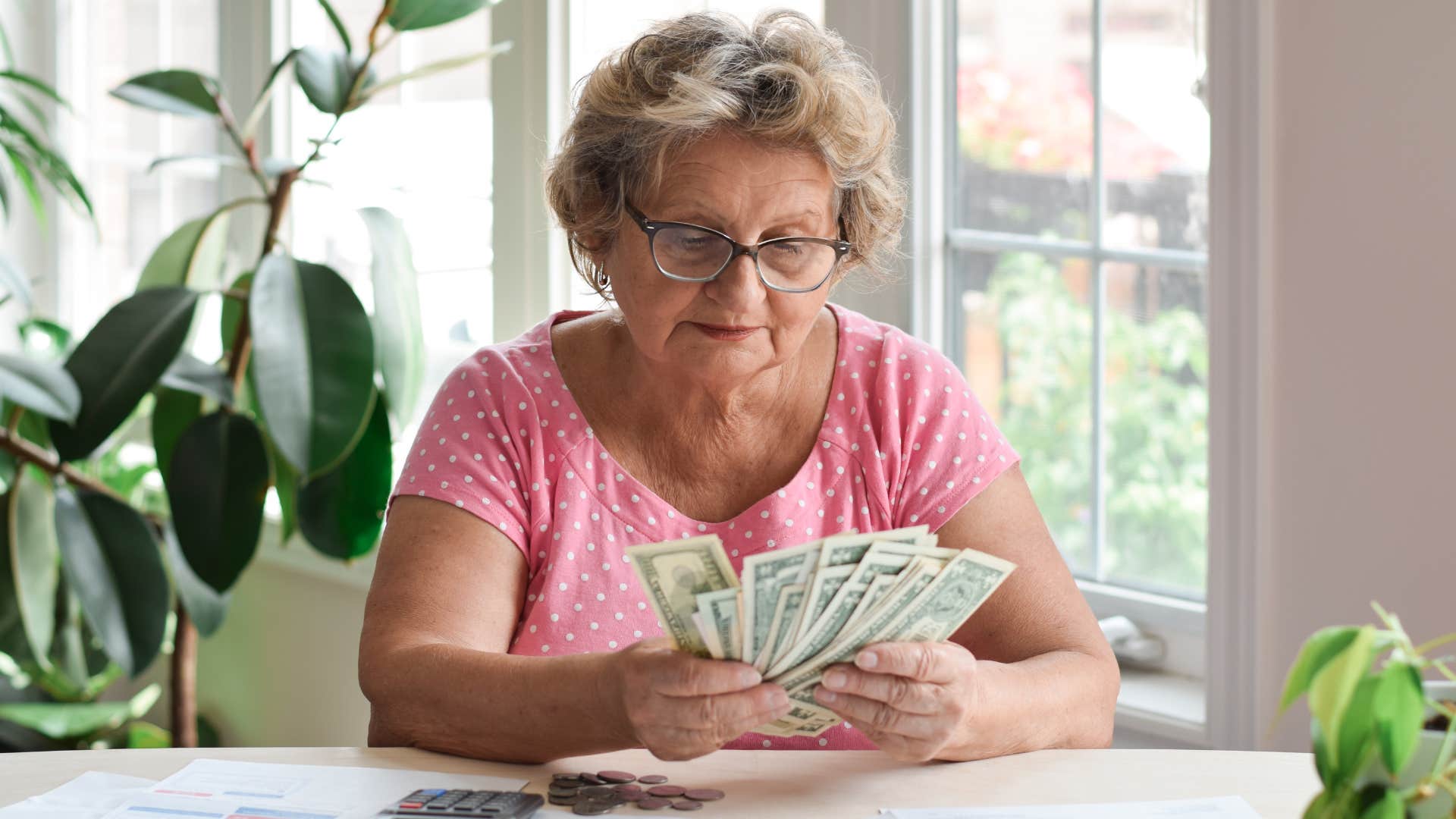 boomer woman holding cash from making her kids pay rent