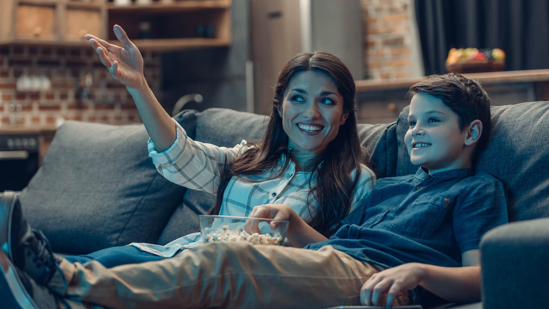 mom watching TV with young son