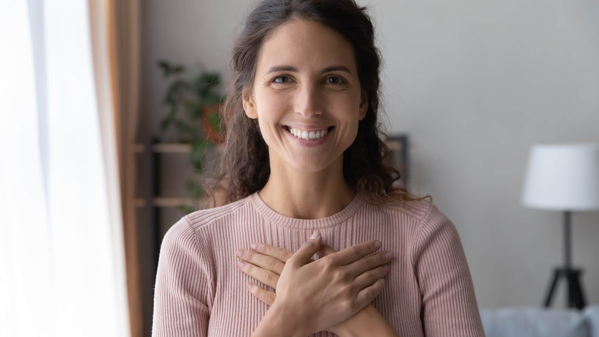 happy woman with her hand over her heart