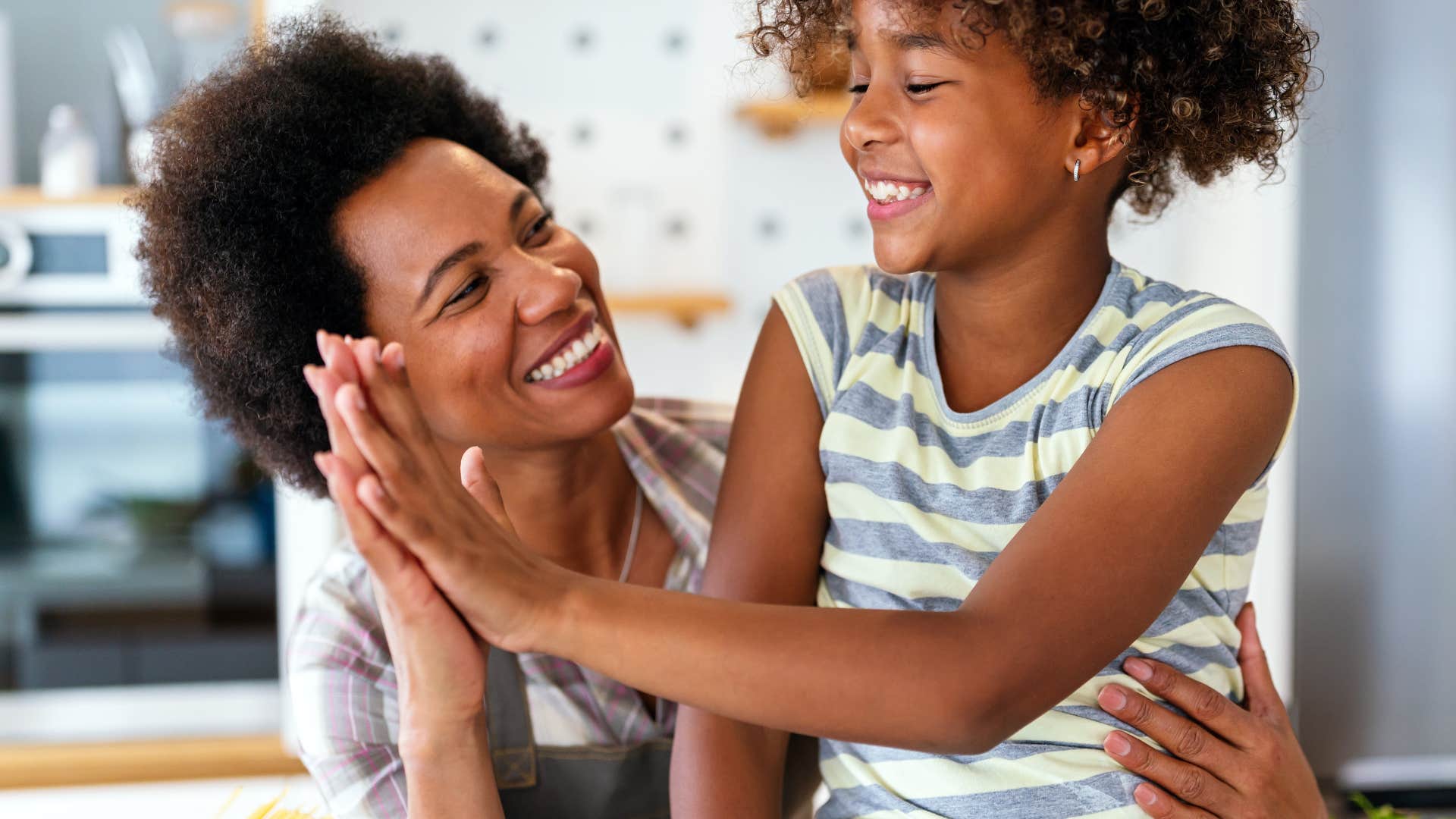 mom giving daughter high five expressing unconditional love