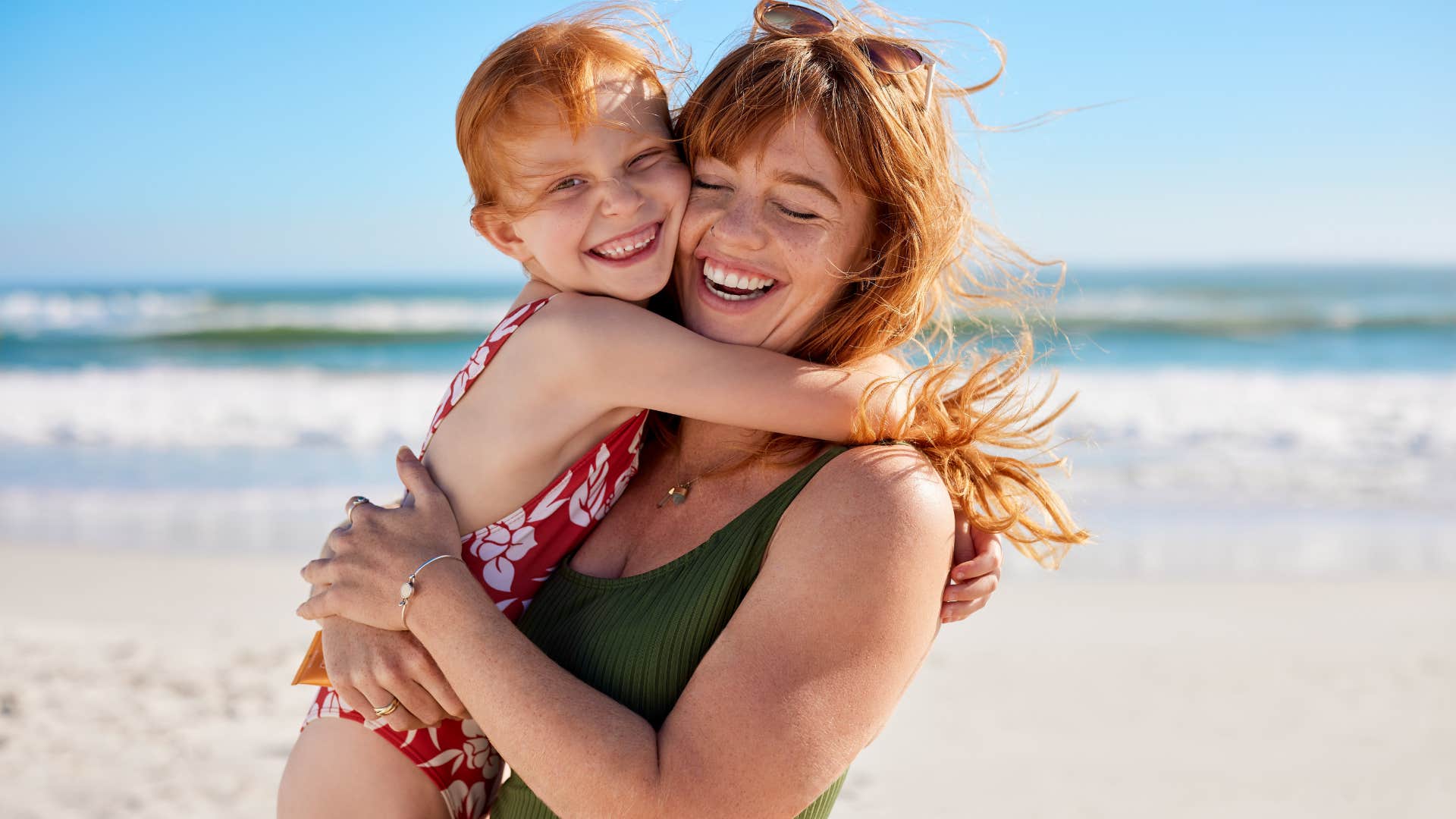 patient mom hugging young daughter on beach