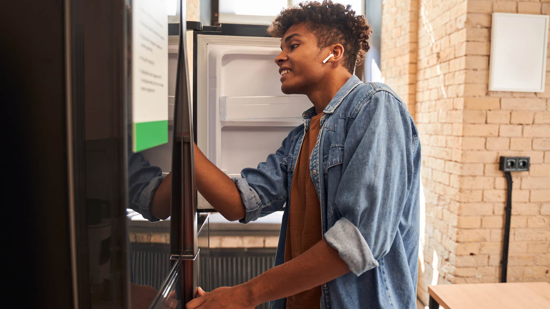 man looking inside a fridge that hasn't been cleaned