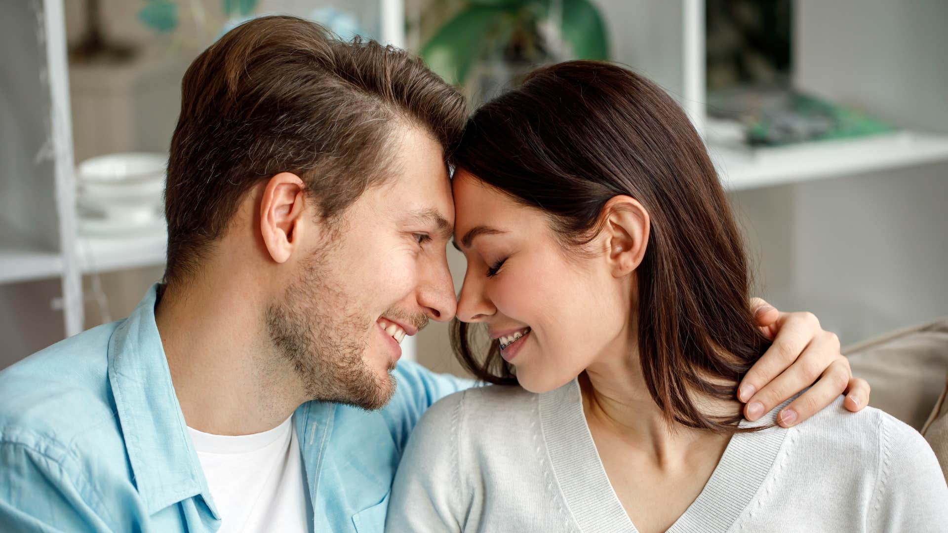 man in blue jacket providing clear direction as he holds woman and puts his forehead against hers