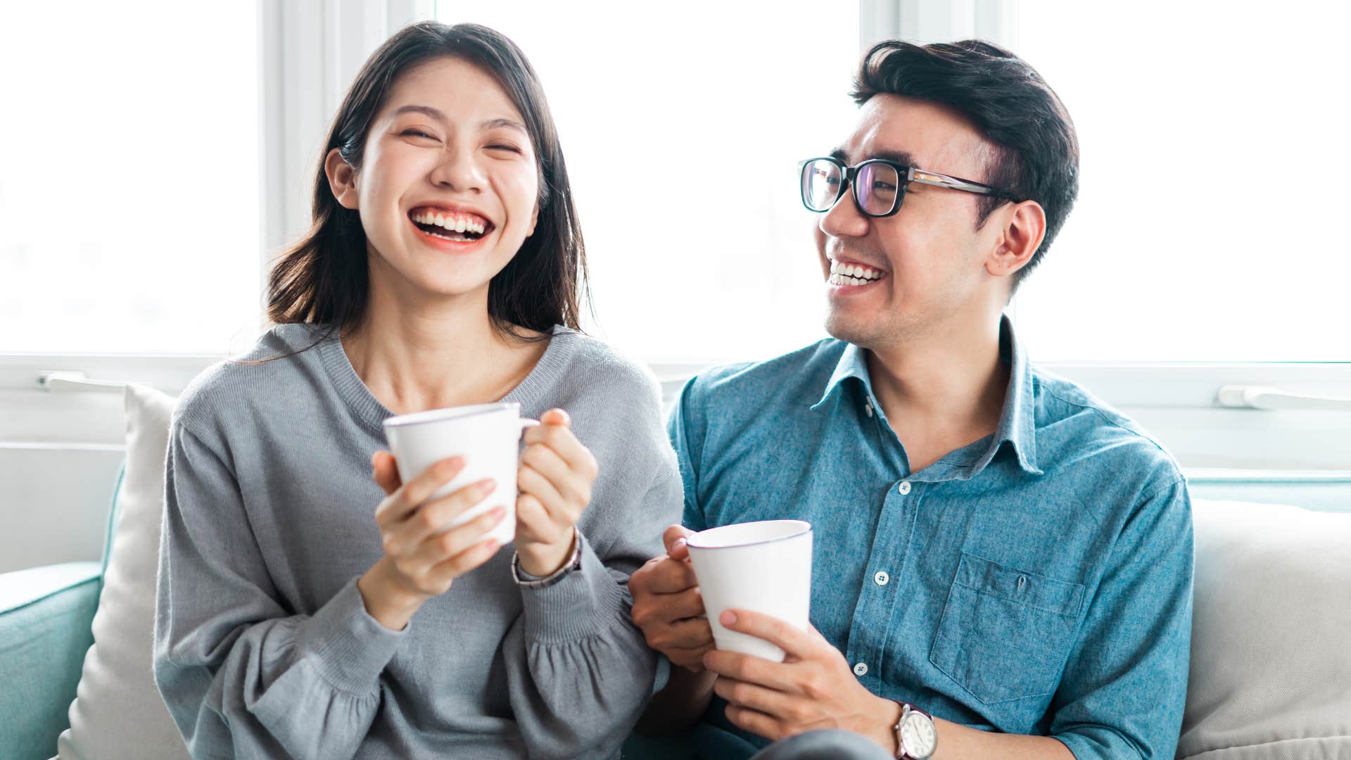 man in blue shirt being consistent and reliable as he looks at woman with coffee and smiles