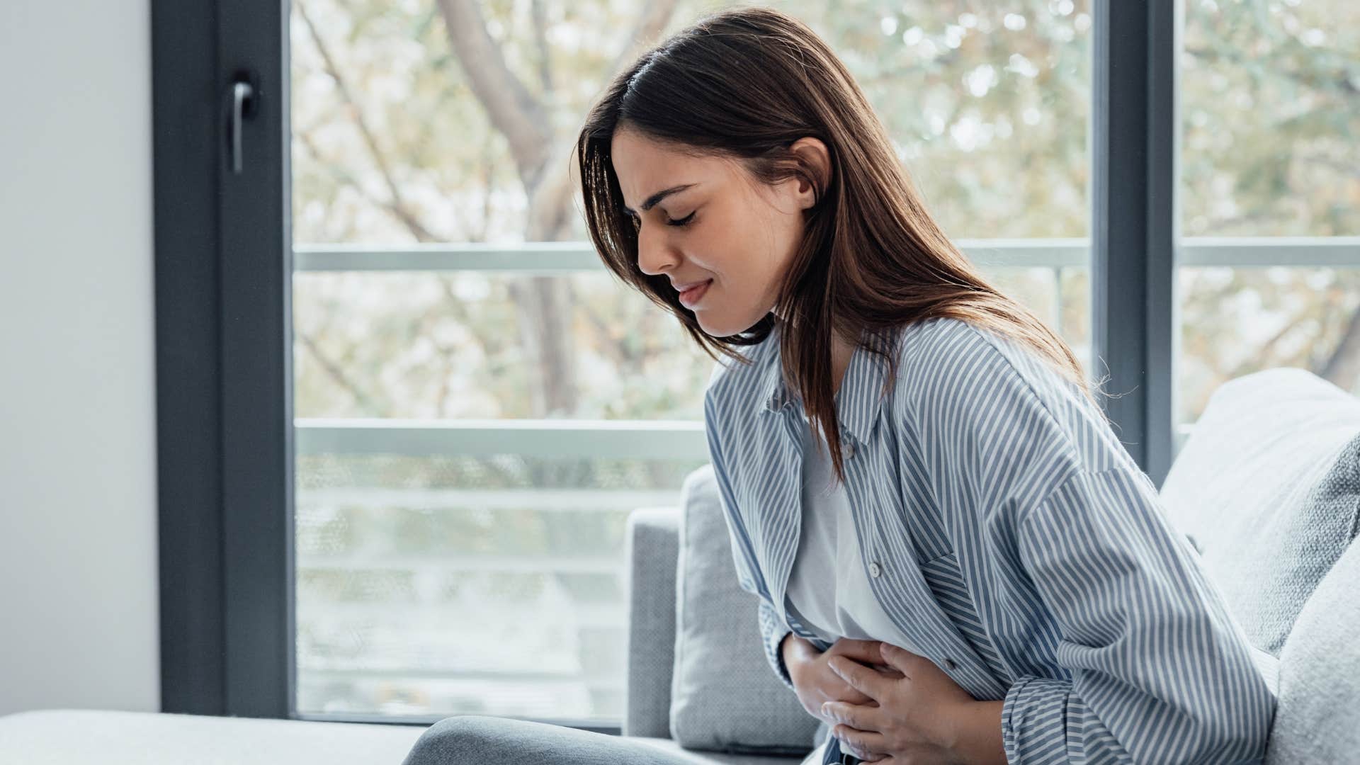 woman in pain holding stomach