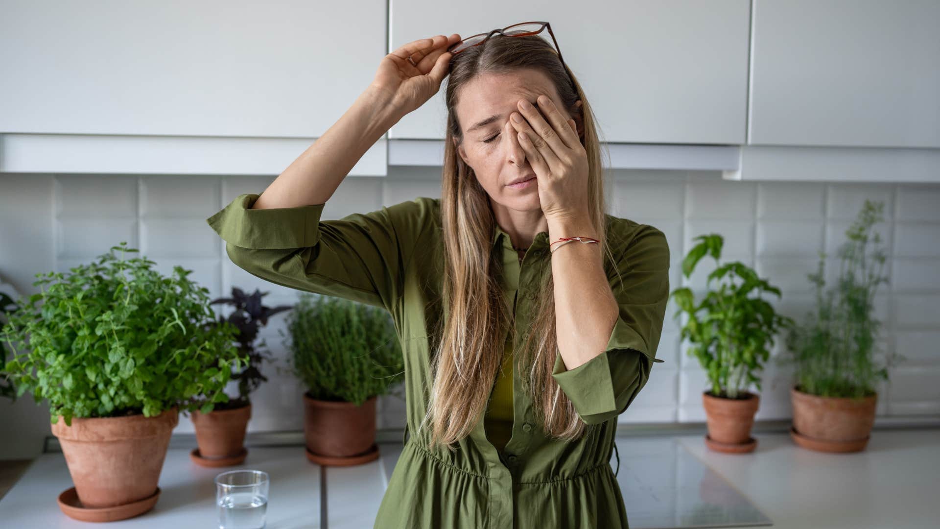 woman rubbing her eye looking exhausted