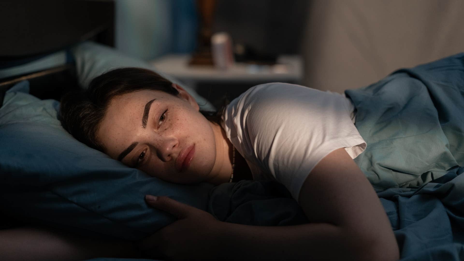 woman laying in bed unable to sleep
