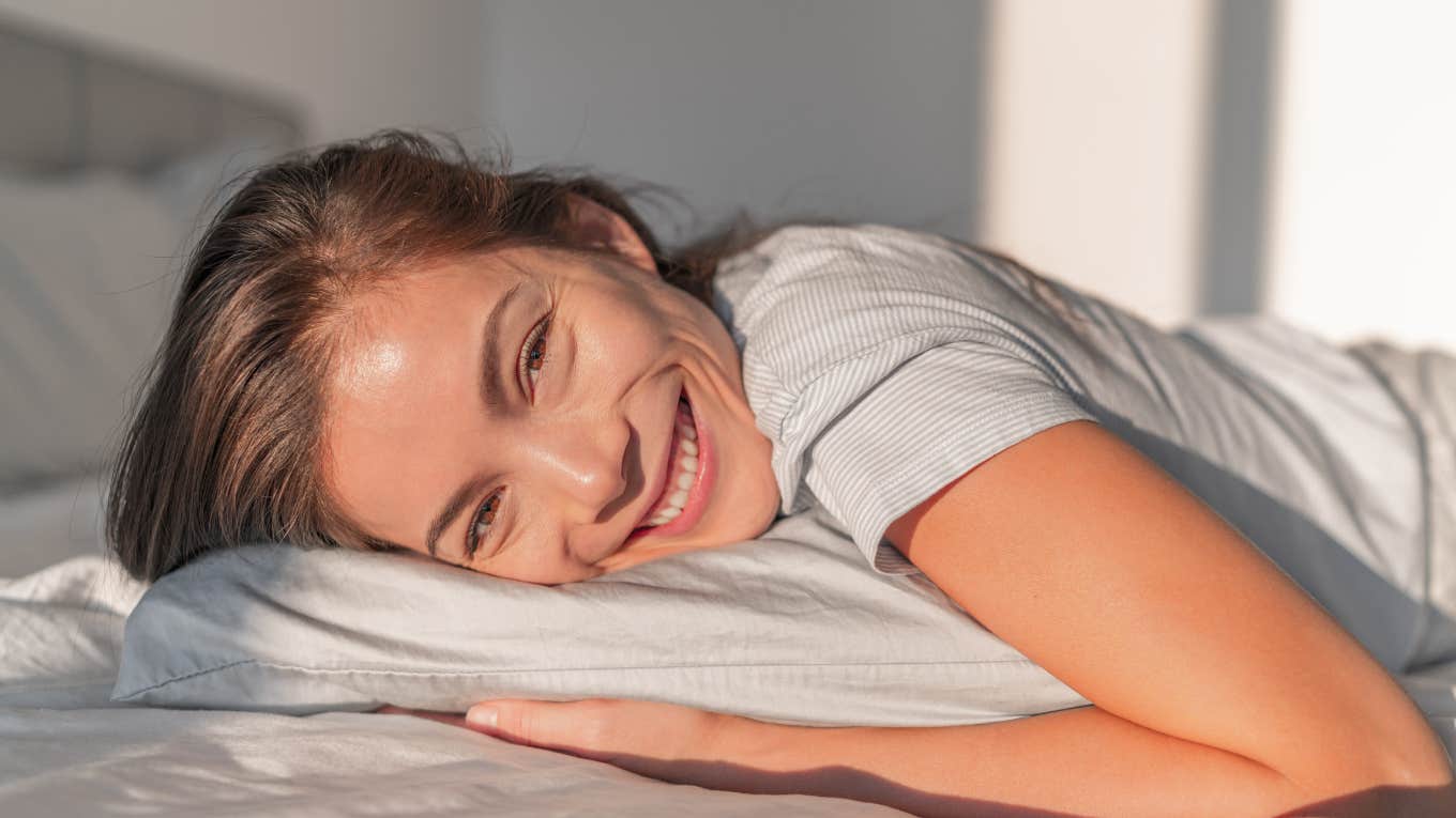 What Your Sleeping Position Says About Your Personality Woman smiling because her sleeping position reveals her personality