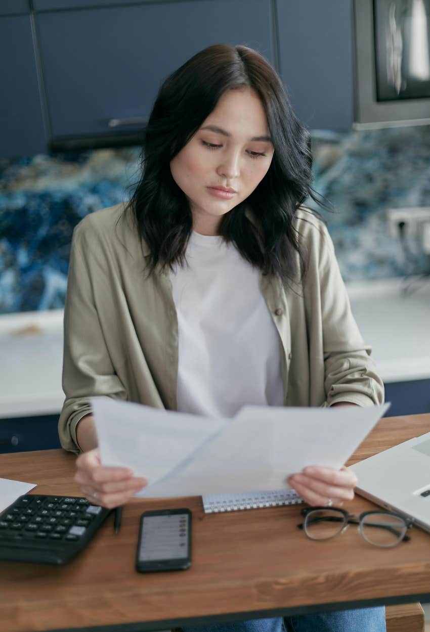 woman looking at bills finding out where her rent money is really going