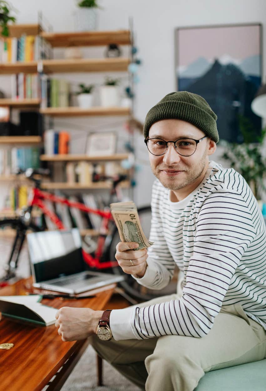 Husband holding money he found on the ground that wife wants to leave him over