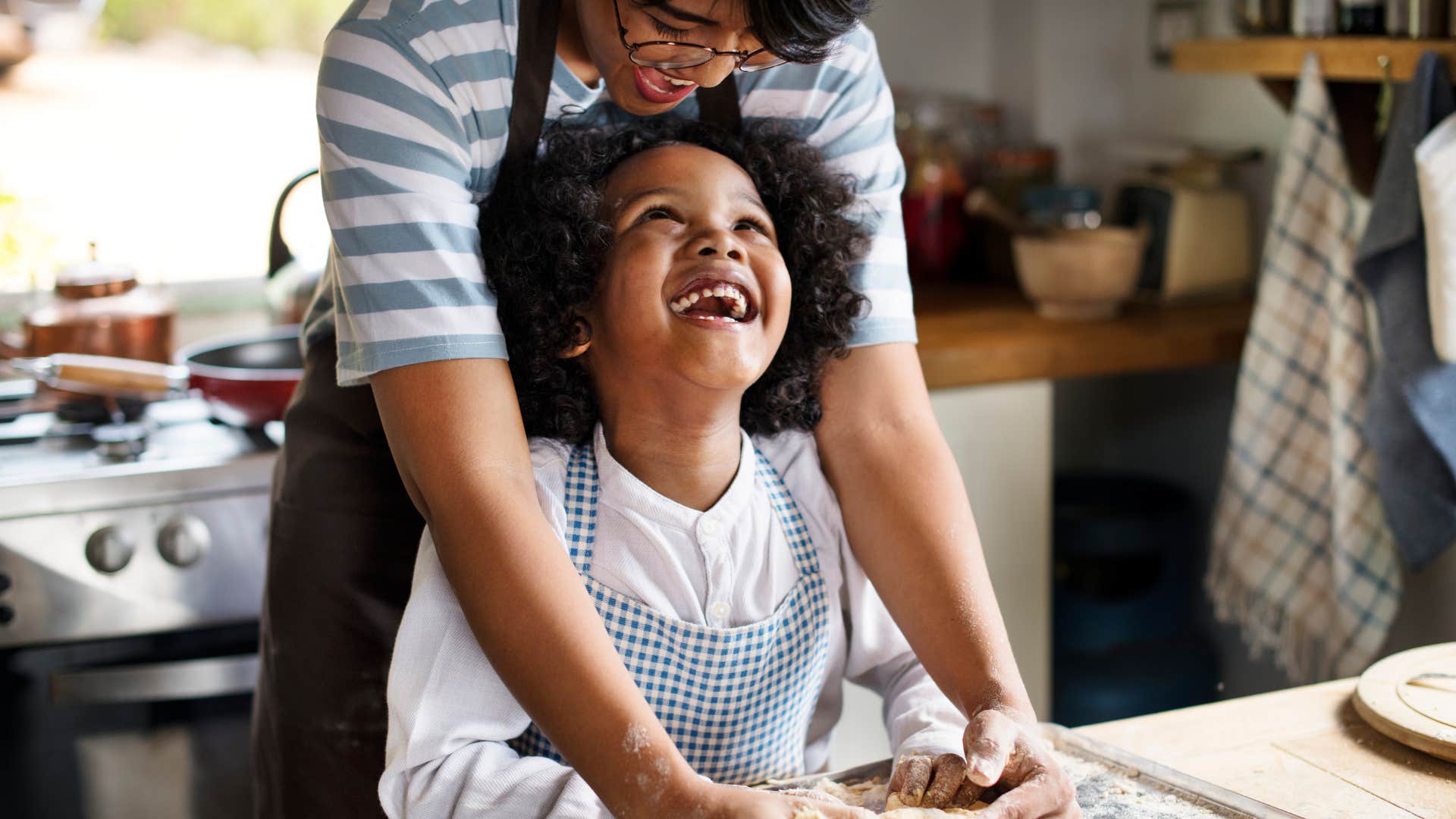Woman teaching her daughter about wasted food while cooking in the kitchen.