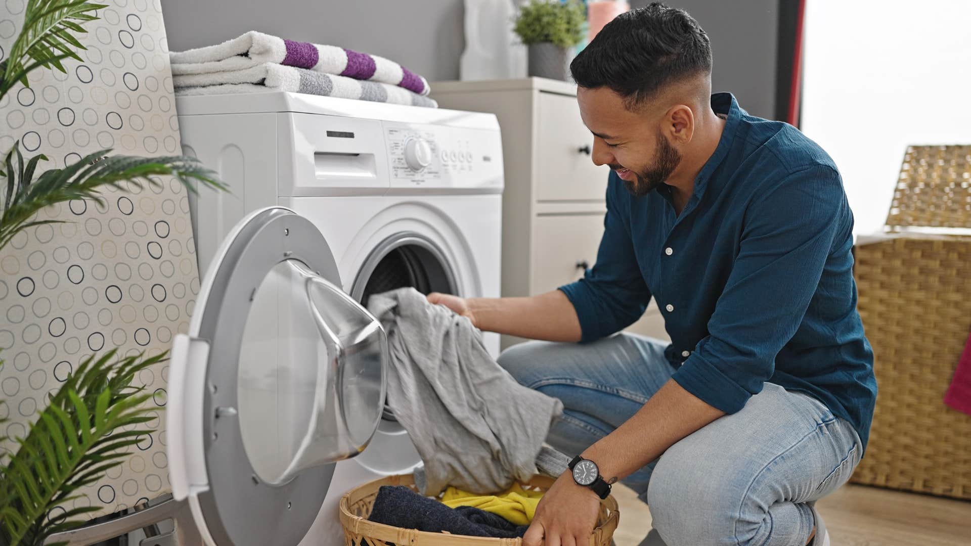 Man cleaning visual chaos in his laundry room at home.