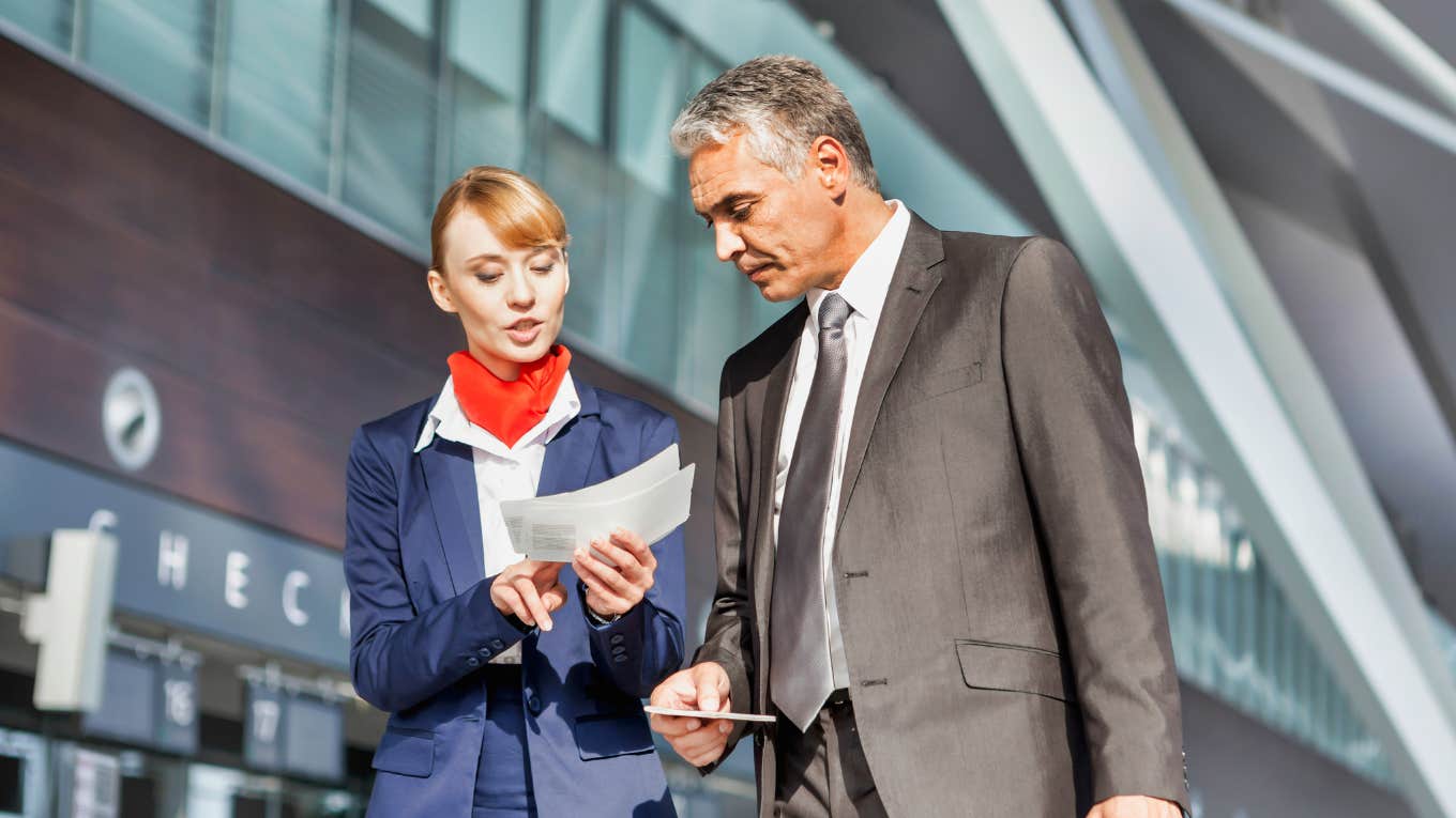 airlines charging single travelers higher fares Airline employee helping traveler