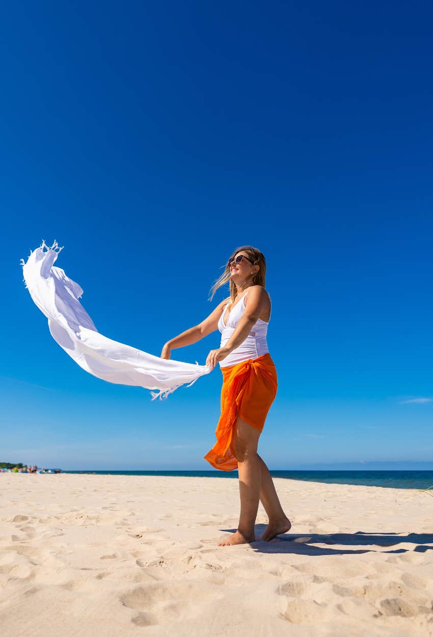 Tourist getting judged by locals for creating a sandstorm by shaking out sandy towel