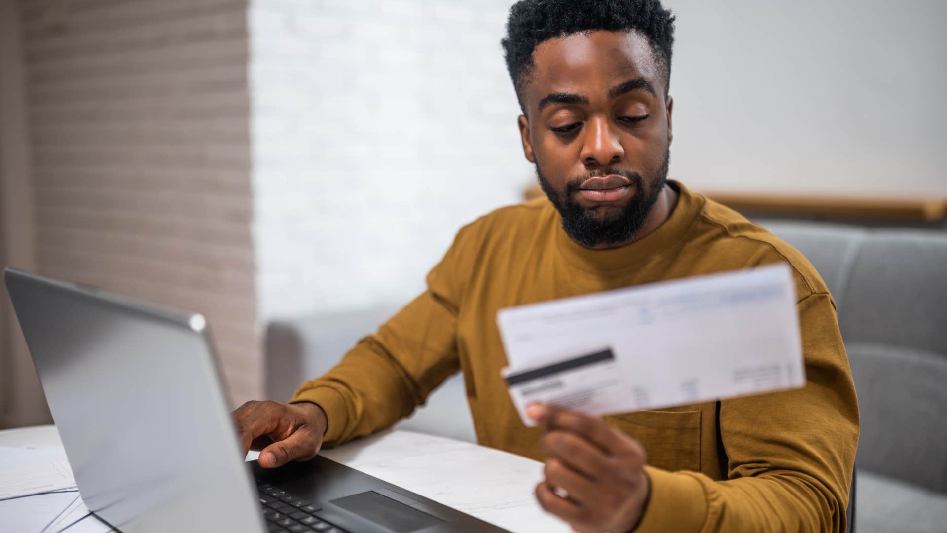 Man doing bills and avoiding debt at home.