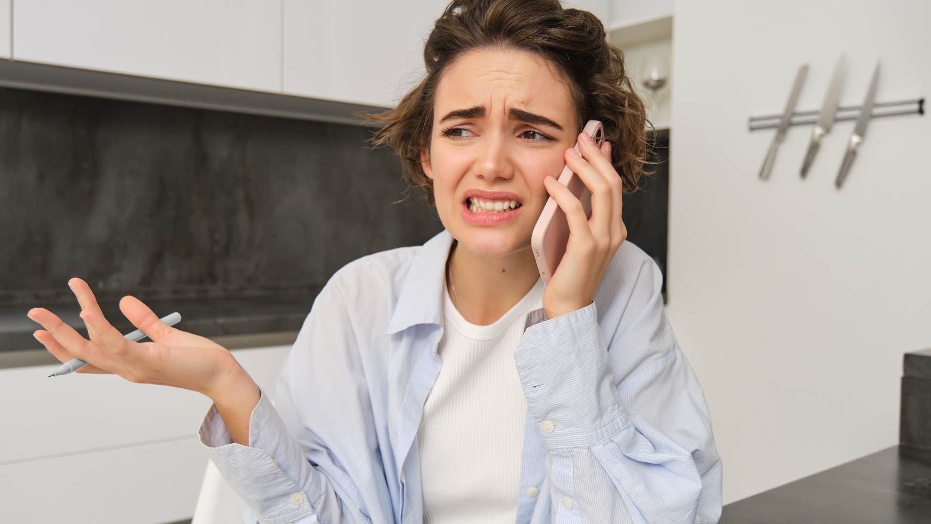 Woman feeling uncomfortable talking about money on the phone.