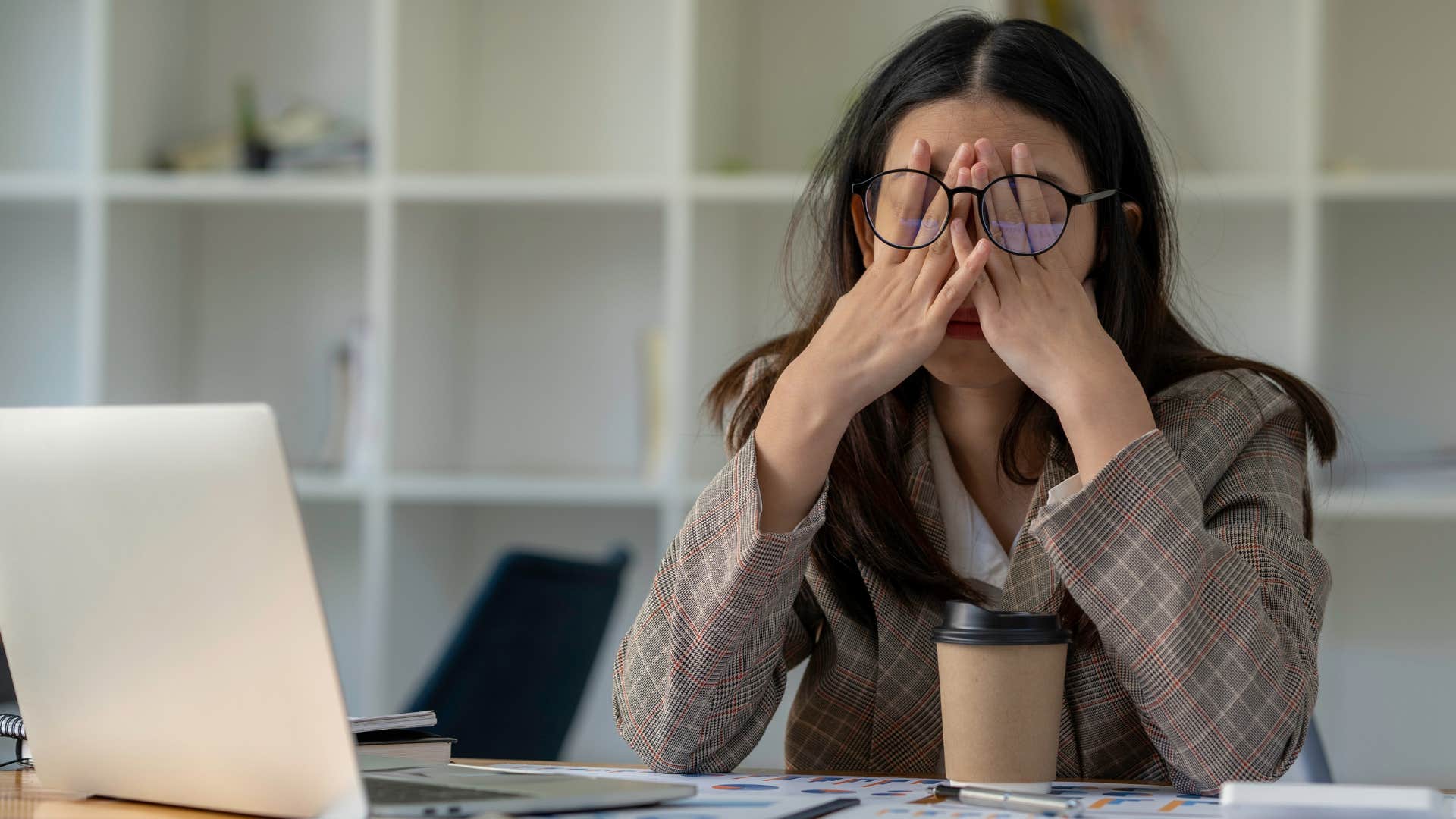 woman who struggles with daily tasks holding her head in her hands