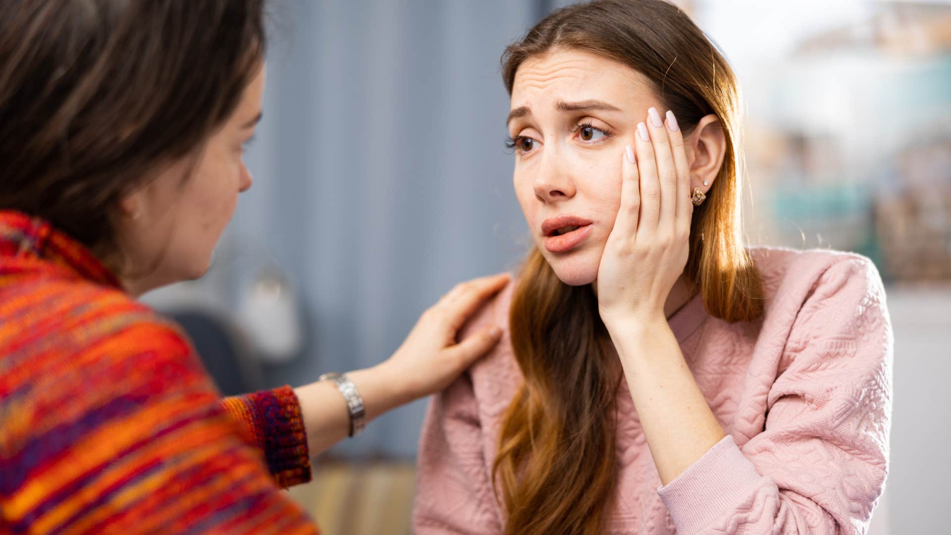 sad woman over-apologizing for her emotions talking to a friend