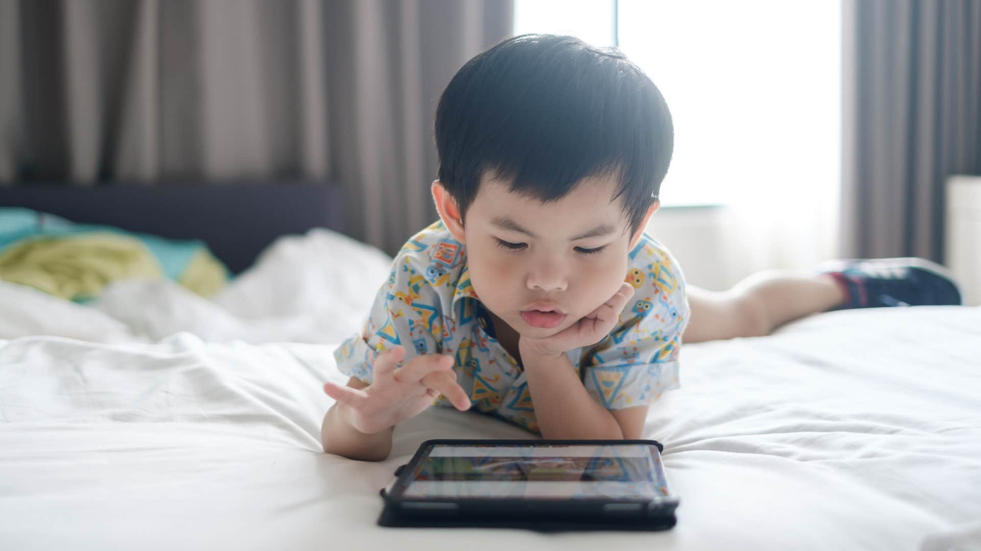 young boy playing on an ipad