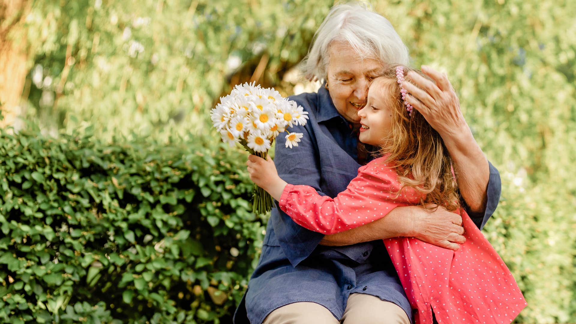 little girl being kind to elderly woman giving her flowers