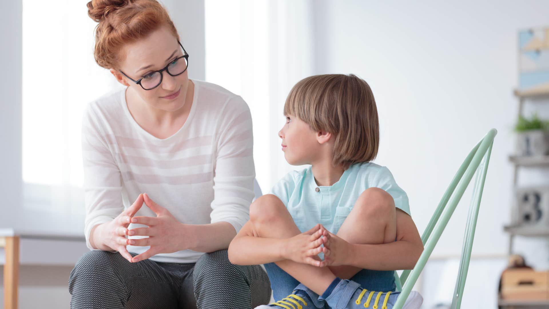 teacher having a conversation with young boy
