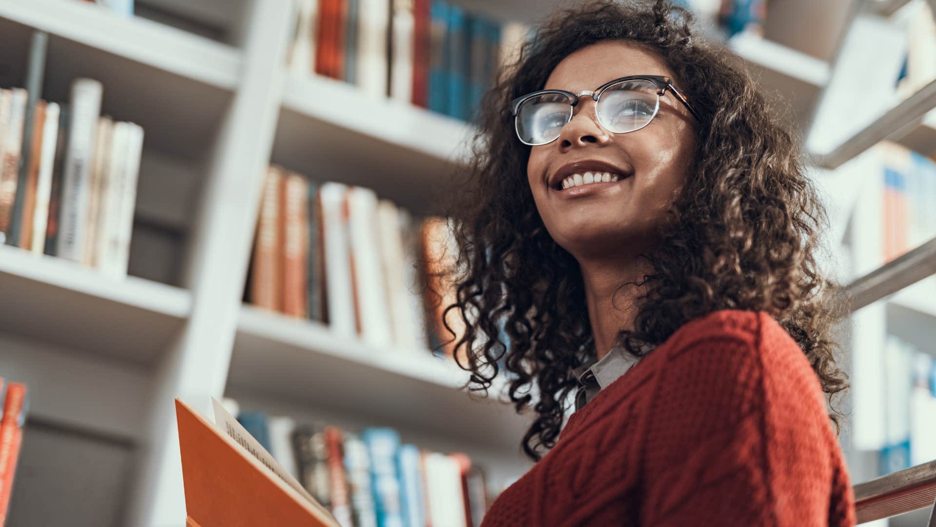 happy woman at the library reading a book