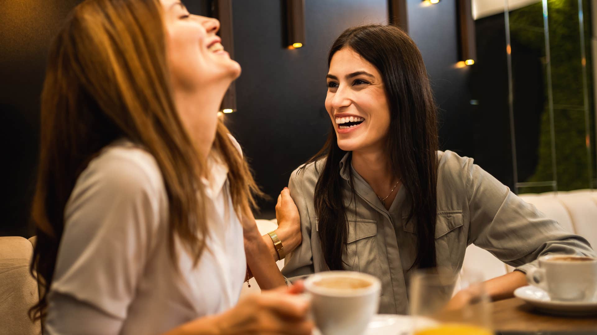 Woman smiling at a friend after not offering to help clean up dinner