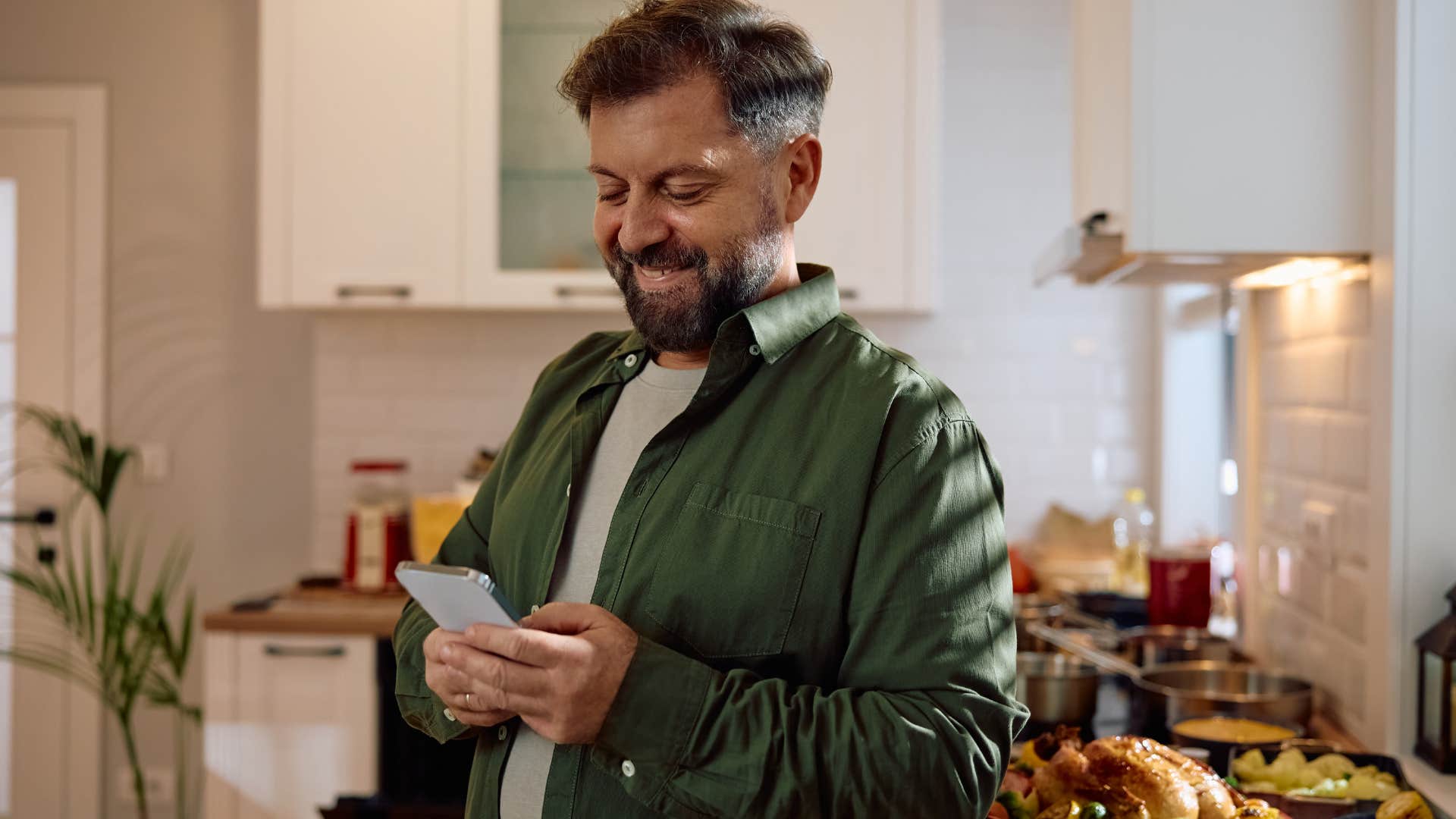 Man using his phone in the kitchen