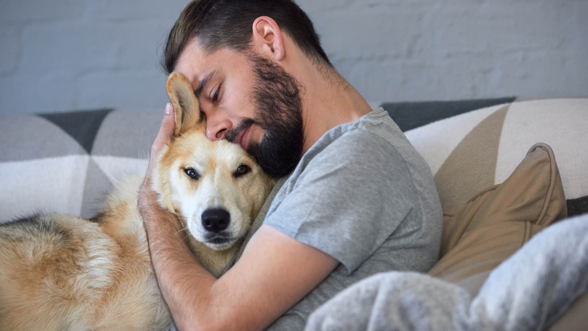 Man who feels their pain as his own hugging his dog.