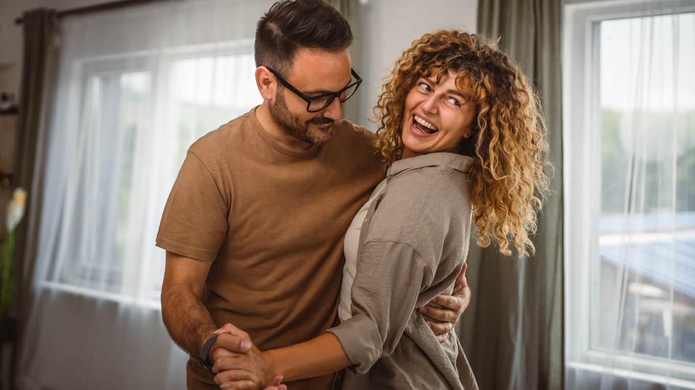 Couple having check-ins and dancing in the living room.