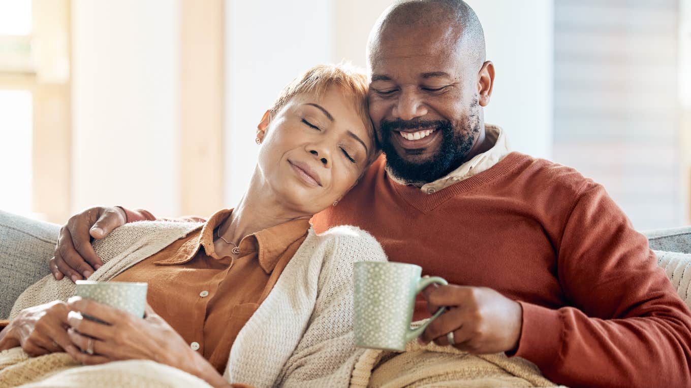 Happy couple sitting in silence and drinking coffee together.