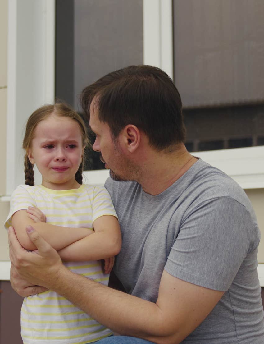 dad talking to little girl crying