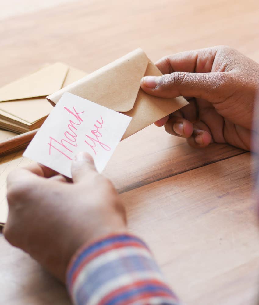 High school principal hand writing thank you notes to school's graduates