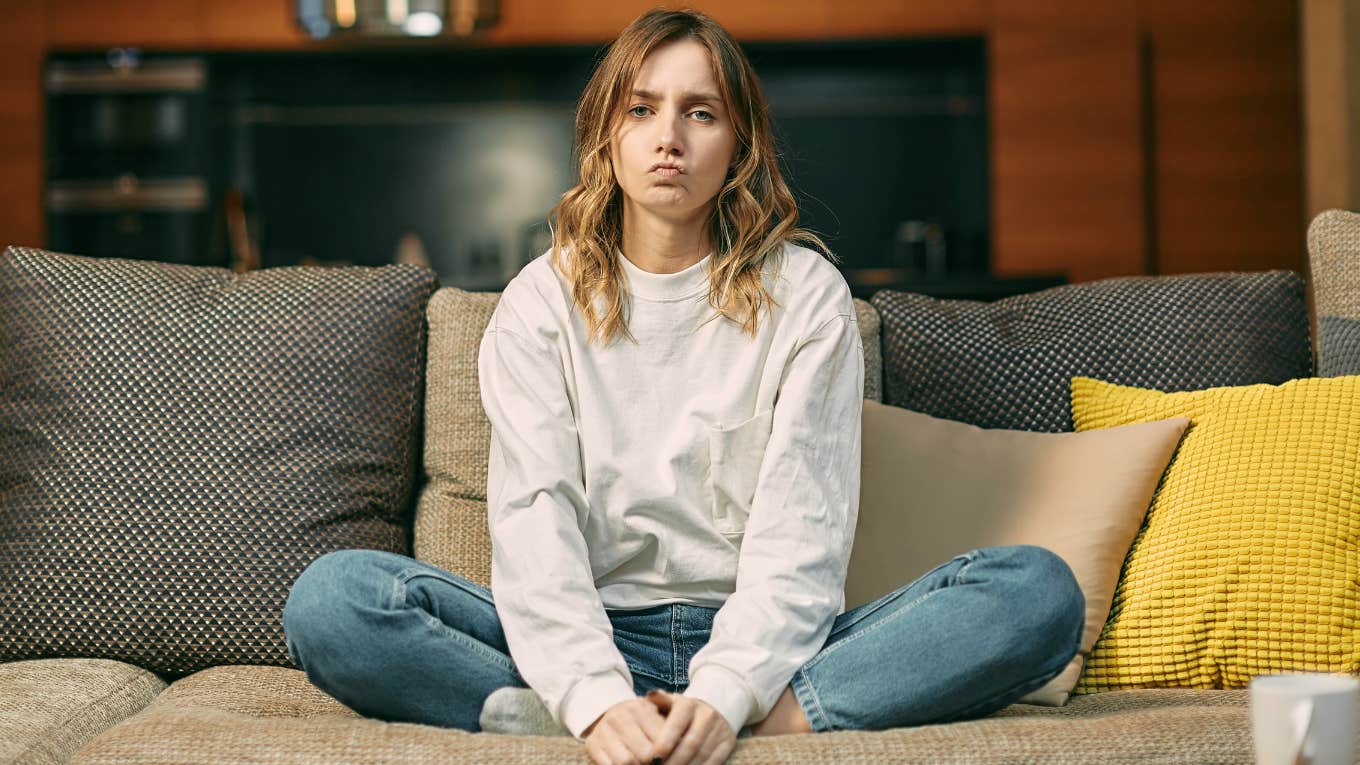Hobbies That Make People Quietly Judge You, Even If They'd Never Admit It young woman sitting on couch quietly judging