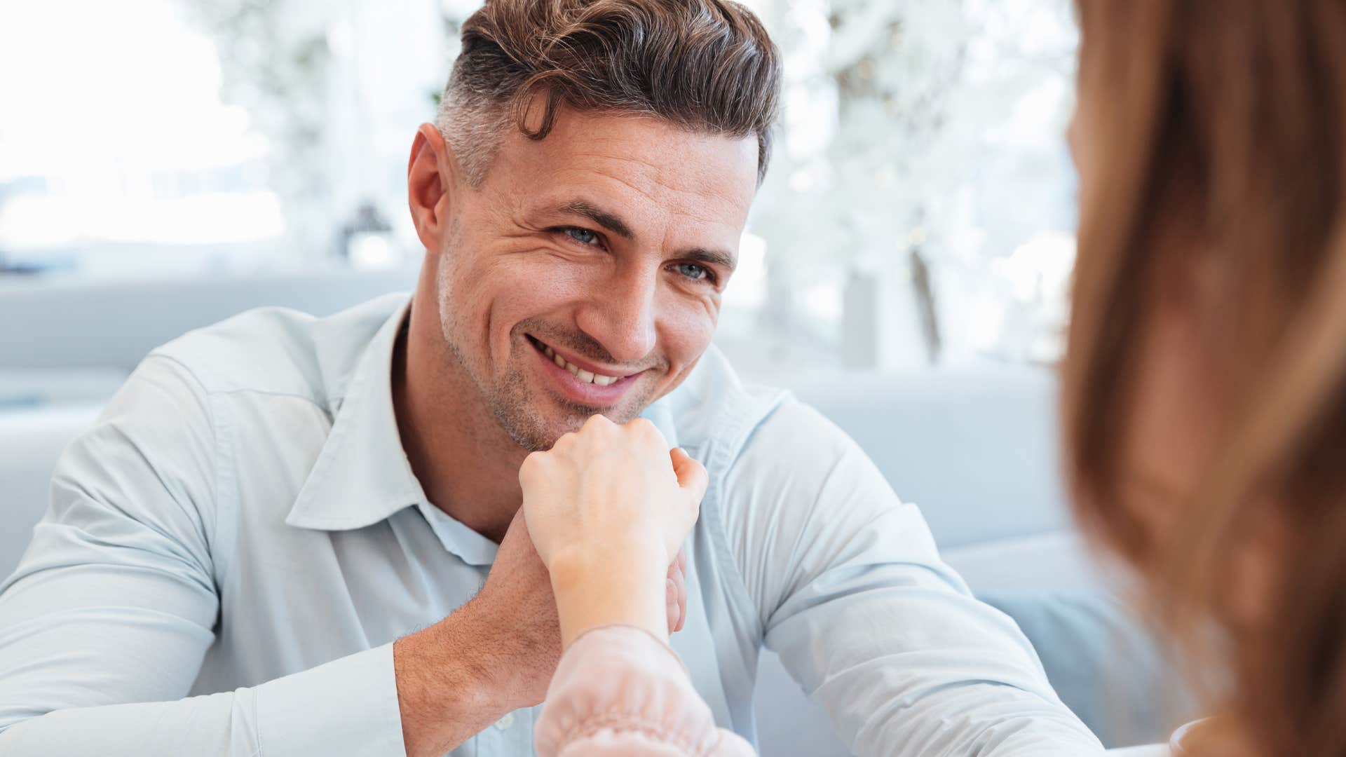 man in blue compliments woman as he smiles brightly at her